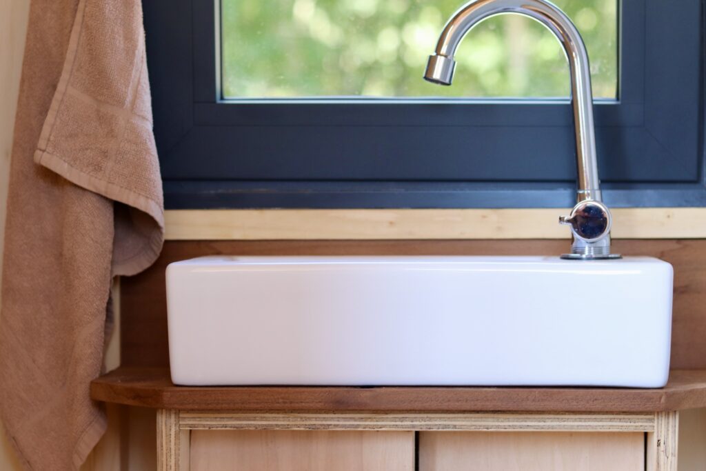 Lavabo et robinet dans la salle d’eau d’un studio mobile TYMUP