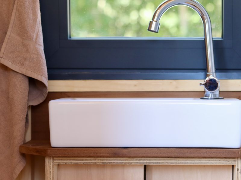 Vasque blanche et plan en bois dans la salle d’eau du studio TYMUP